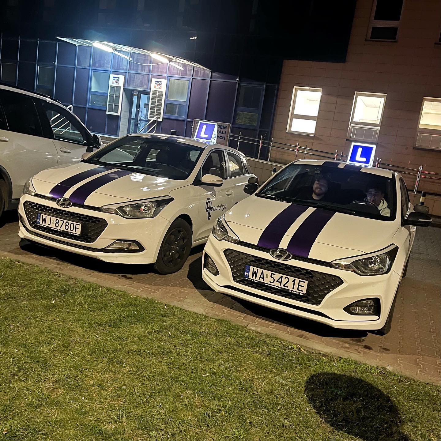 Instruktor i kursant w samochodzie, instruktor pokazuje palcem OK